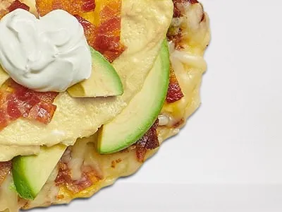 First Watch Bacado Omelet - fluffy omelet filled with bacon, avocado, and Monterey Jack cheese, topped with sour cream.