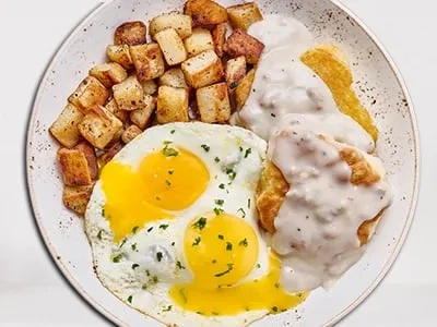 First Watch Biscuits & Turkey Sausage Gravy - house-baked buttermilk biscuit topped with creamy turkey sausage gravy, served with eggs and seasoned potatoes.