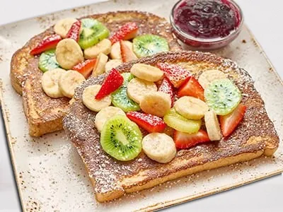 First Watch Floridian French Toast - thick slices of toast topped with fresh bananas, strawberries, and powdered sugar.