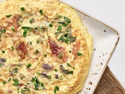 First Watch Frittata Rustica - an Italian-style omelet with kale, roasted crimini mushrooms, onions, and tomatoes, topped with Mozzarella and Parmesan cheese.