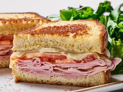 Ham and Gruyere Melt from First Watch, featuring smoked ham, melted Gruyere cheese, fresh tomato, and Dijonnaise on grilled artisan brioche bread.