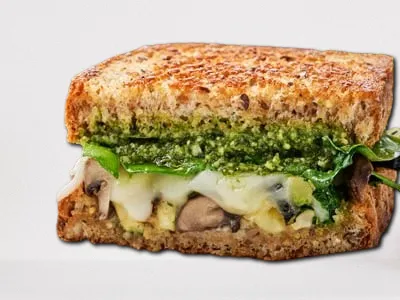 Market Veggie Sandwich from First Watch, featuring house-roasted Crimini mushrooms, zucchini, spinach, basil pesto, mayo, and Mozzarella on grilled artisan whole grain bread.