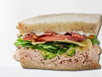 Monterey Club Sandwich from First Watch, featuring turkey, bacon, avocado, organic mixed greens, tomato, Monterey Jack cheese, and mayo on sourdough bread.
