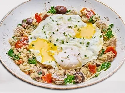 First Watch Power Breakfast Quinoa Bowl - protein-packed quinoa with Italian sausage, roasted vegetables, kale, and basted cage-free eggs.
