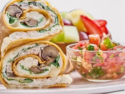 First Watch Power Wrap - a sun-dried tomato-basil tortilla filled with cage-free egg whites, turkey, spinach, house-roasted Crimini mushrooms, and Mozzarella cheese, served with fresh fruit and house-made pico de gallo.