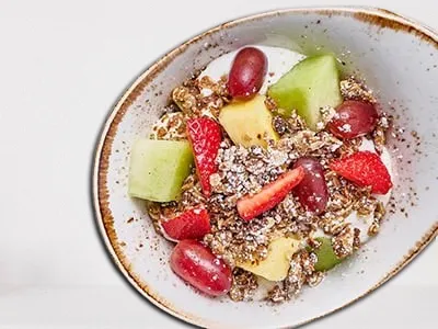 First Watch Sunrise Granola Bowl - non-fat vanilla Greek yogurt layered with fresh seasonal fruit and house-made granola with almonds, served with a freshly baked muffin.
