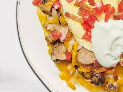 First Watch The Works Omelet - a hearty omelet filled with ham, bacon, sausage, house-roasted Crimini mushrooms, onions, and tomatoes, topped with Cheddar, Monterey Jack cheese, and all-natural sour cream.