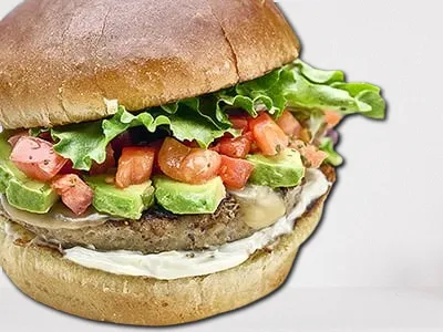 Veggie Burger from First Watch, featuring a seasoned all-natural patty made with brown rice, Peppadew peppers, onions, carrots, and mushrooms, served on a brioche bun with fresh smashed avocado, organic mixed greens, tomato, red onion, and a side of Dijonnaise.
